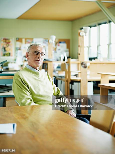 mature businessman seated at conference table - newbusiness stock pictures, royalty-free photos & images