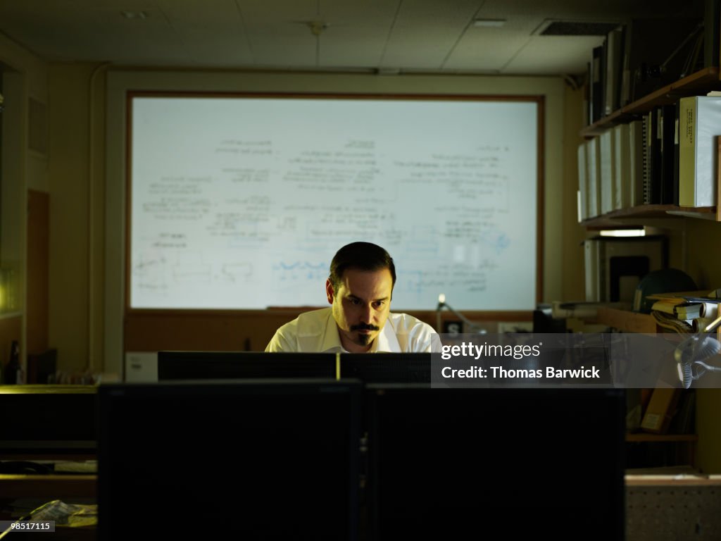 Businessman looking at computer monitors in office