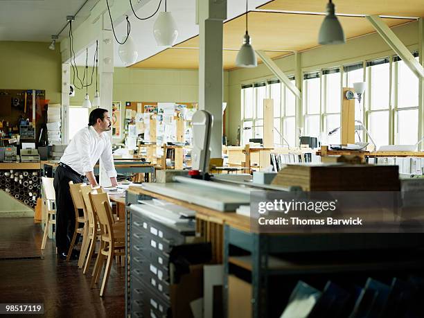 businessman standing in empty office - newbusiness fotografías e imágenes de stock