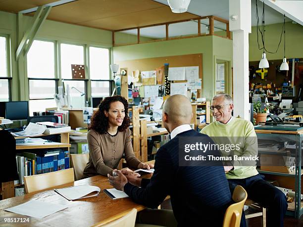 coworkers in discussion at conference table - newbusiness stock pictures, royalty-free photos & images