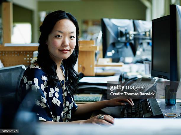 businesswoman working on computer at workstation - newbusiness stock pictures, royalty-free photos & images