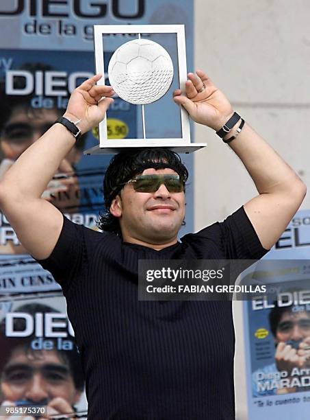 The ex-soccer player Diego Maradona shows the prize which is awarded him as the best player of the world, chozen by the FIFA internet inquiry, in...