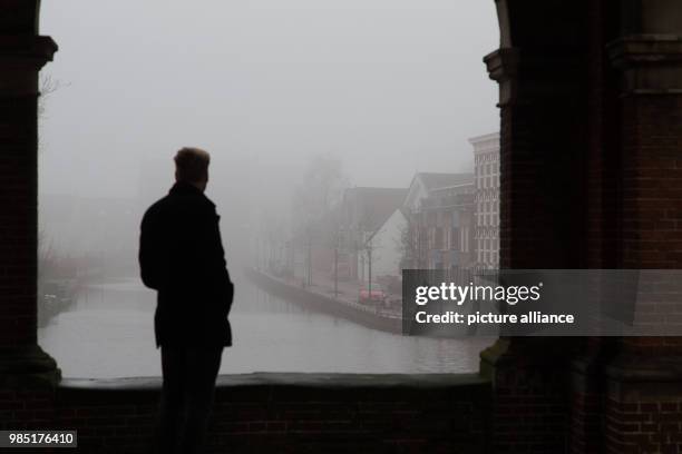 Man standing in an archway in front of the Water Gate in the Dutch city Sneek in the Netherlands, 26 January 2018. The nearby city Leeuwarden in the...