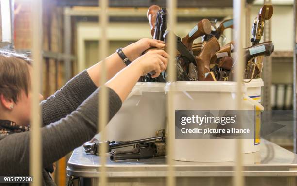 Hand guns are placed in buckets by employee Kathrin Bettler in the secured chamber for evidence objects of the weapons authority of the Osnabrueck...