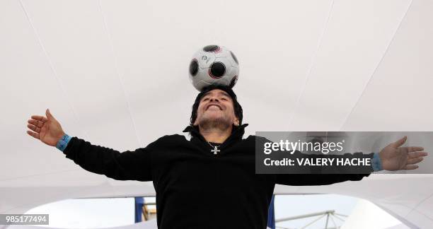 Former Argentinian football player Diego Maradona controls the ball as he poses during a photocall for Serbian director Emir Kusturica's film...