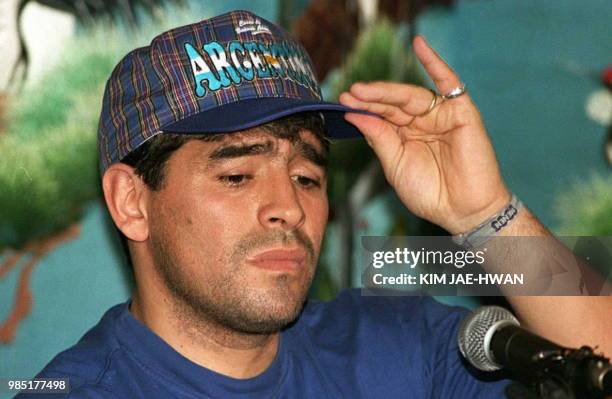 Argentinian soccer star Diego Maradona fixes his cap during a press conference in Seoul 22 September. Maradona said that he was making a comeback...