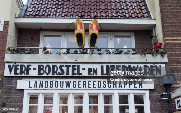 Dpatop - Wooden shoes hanging over a shop for garden tools in the Dutch city Leeuwarden in the Netherlands, 26 January 2018. Leeuwarden in the...
