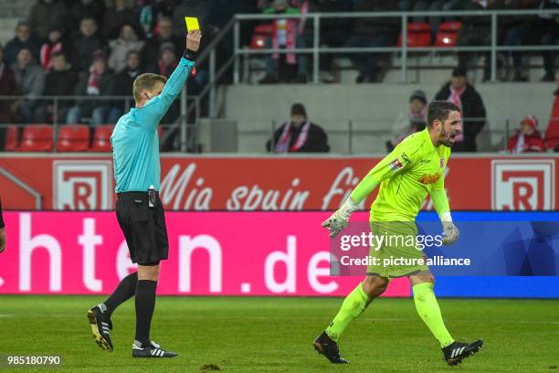 Regensburg's goalkeeper Philipp Pentke is shown the yellow card by referee Timo Gerach during the German 2nd division Bundesliga soccer match between...