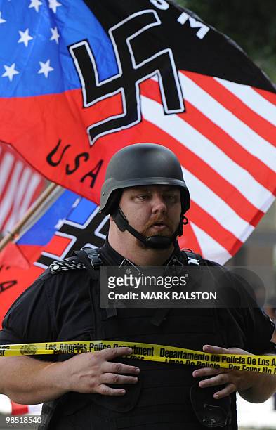 Member of the Neo-Nazi group, The American National Socialist Movement watches an angry crowd of counterprotesters as the group held a rally in front...