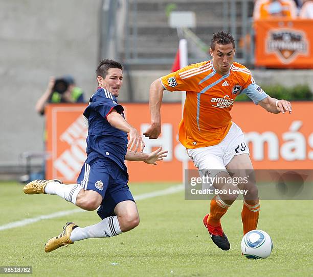 Geoff Cameron of the Houston Dynamo is tripped up by Sacha Kljestan of Chivas USA at Robertson Stadium on April 17, 2010 in Houston, Texas.