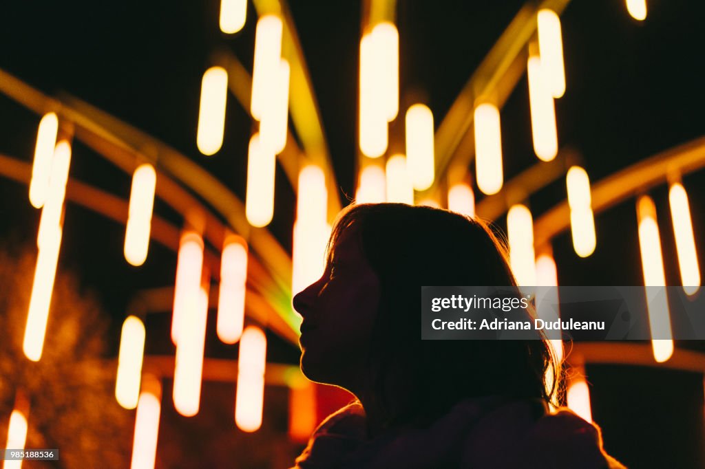 Low Angle View Of Silhouette Woman Against Illuminated Lights At Night