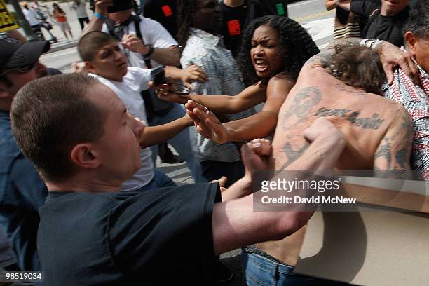 Woman tries to stop an attack on a reportedly homeless man by anti-neo-Nazi demonstrators before the start of a rally by the National Socialist...