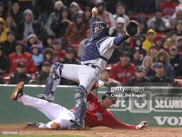 Dioner Navarro of the Tampa Bay Rays falls as J.D. Drew of the Boston Red Sox is out on a fielder's choice in the 11th inning at Fenway Park on April...