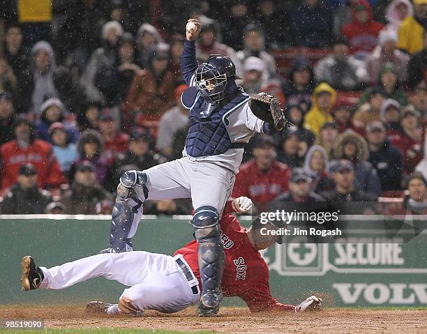 Dioner Navarro of the Tampa Bay Rays falls as J.D. Drew of the Boston Red Sox is out on a fielder's choice in the 11th inning at Fenway Park on April...