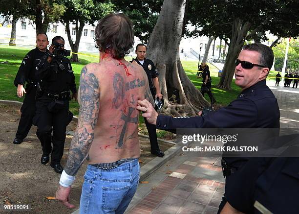 Police remove a man with nazi skin tattoo's after he was beaten by an angry crowd of counterprotesters before the neo-nazi group, The American...