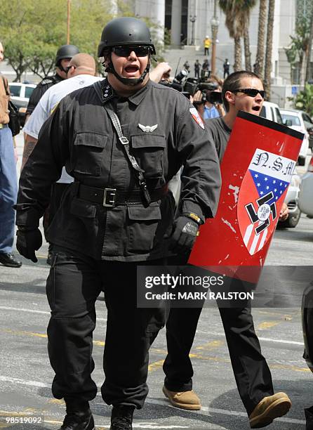 Members of the neo-nazi group, The American National Socialist Movement group use shields to shelter from rocks and bottles thrown by an angry crowd...