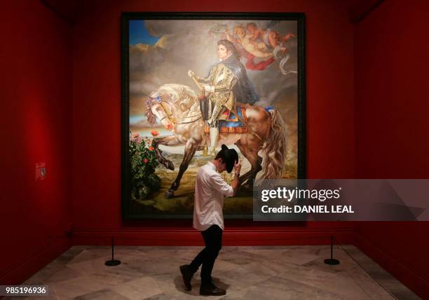 Gallery assistant poses next to an artwork entitled Equestrian Portrait of King Phillip II by US artist Kehinde Wiley, on display during a photocall...