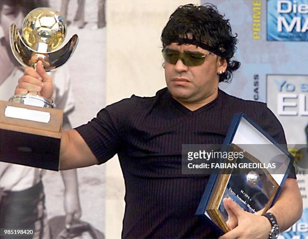 The ex-soccer player Diego Maradona shows the prize which is awarded him as the best player of the world, chozen by the FIFA internet inquiry, in...
