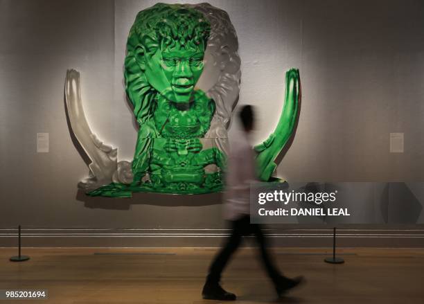 Gallery assistant poses next to an artwork entitled Green Grey Symmetrical Michael Jackson by US artist Paul McCarthy, on display during a photocall...