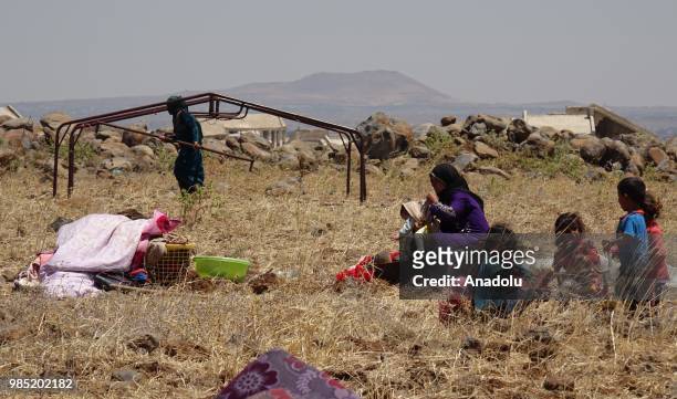 Syrian families are seen near the Golan Heights and the Israel-Jordan border after they fled from the ongoing military operations by Bashar al-Assad...