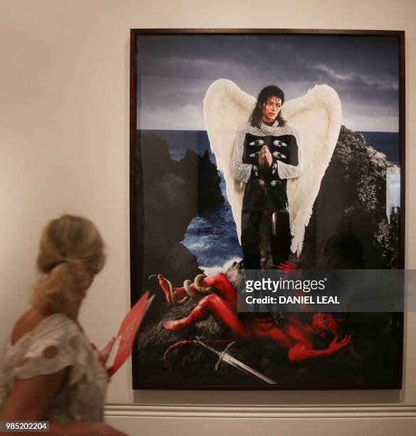Visitor walks past an artwork entitled 'Archangel Michael: And No Message Could Have Been Any Clearer' by US artist David LaChapelle, on display...