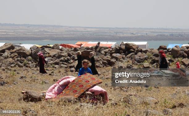 Syrian families are seen near the Golan Heights and the Israel-Jordan border after they fled from the ongoing military operations by Bashar al-Assad...