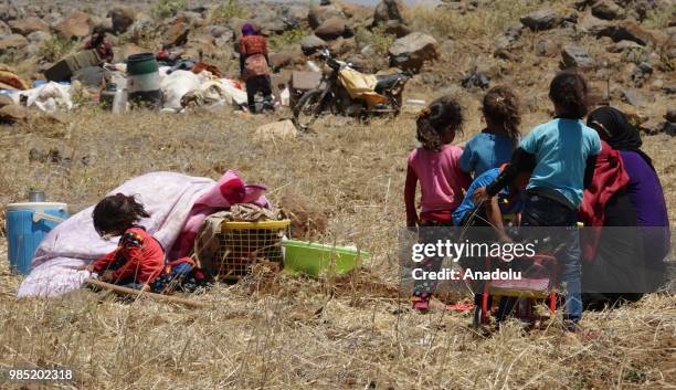 Syrian families are seen near the Golan Heights and the Israel-Jordan border after they fled from the ongoing military operations by Bashar al-Assad...