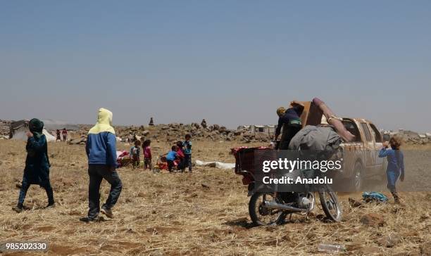 Syrian families are seen near the Golan Heights and the Israel-Jordan border after they fled from the ongoing military operations by Bashar al-Assad...