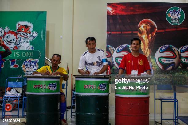 The election committees wear the costumes of participating countries of the World Cup 2018 during regional election in Surakarta, Central Java,...