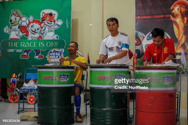 The election committees wear the costumes of participating countries of the World Cup 2018 during regional election in Surakarta, Central Java,...