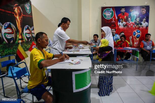 The election committees wear the costumes of participating countries of the World Cup 2018 during regional election in Surakarta, Central Java,...