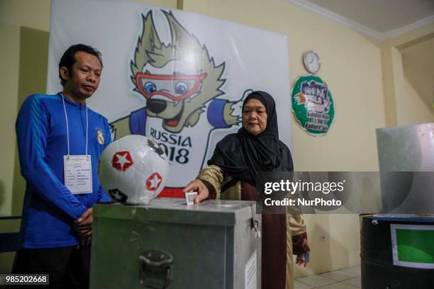 The election committees wear the costumes of participating countries of the World Cup 2018 during regional election in Surakarta, Central Java,...