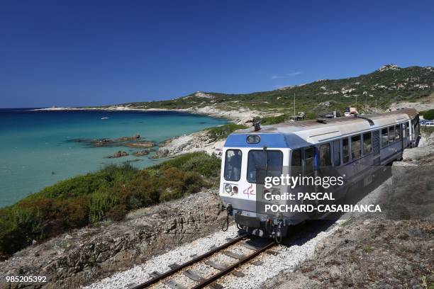 Train travels past a beach near the bay of Calvi on June 26, 2018 on the French Mediterranean island of Corsica. - Since January 2012, the Corsica...