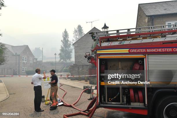 Fire fighters discuss the operation on Calico Close as a large wildfire sweeps across the moors between Dovestones and Buckton Vale in Stalybridge,...