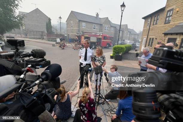 David Keelan from Greater Manchester Fire and Rescue speaks to media on Calico Close as a large wildfire sweeps across the moors between Dovestones...