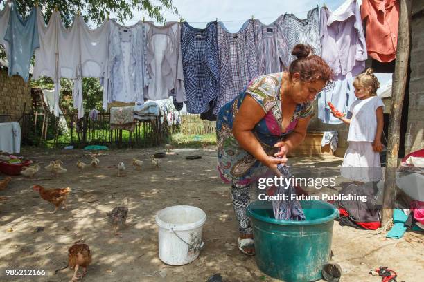 Yeva Rats washes clothes in the yard in a Roma camp, Barkasovo village, Mukachevo district, Zakarpattia Region, western Ukraine, June 26, 2018....