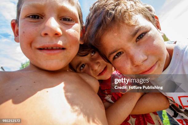 Roma children look into the camera as they live in a camp in Barkasovo village, Mukachevo district, Zakarpattia Region, western Ukraine, June 26,...