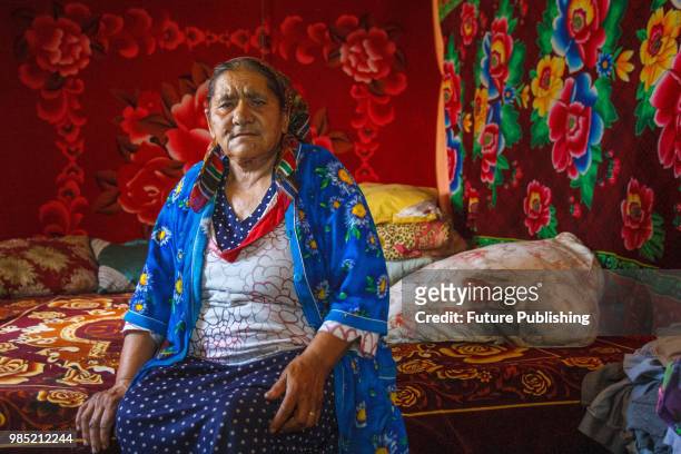 Grandmother of the wife of Davyd Pap who was stabbed to death during the attack on a Roma camp near Lviv sits on the bed in a house, Barkasovo...