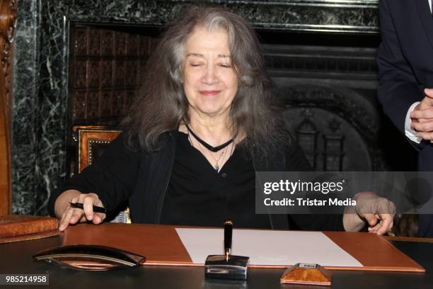 Swiss-Argentinian pianist Martha Argerich signs the golden book at Hamburg City Hall on June 27, 2018 in Hamburg, Germany.