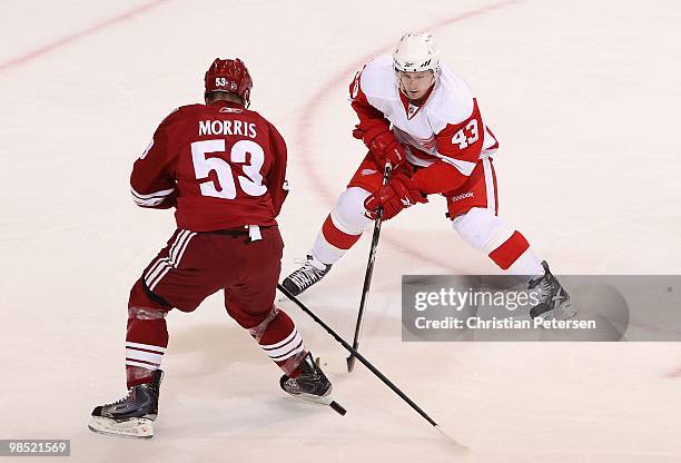 Darren Helm of the Detroit Red Wings skates with the puck past Derek Morris of the Phoenix Coyotes in Game Two of the Western Conference...