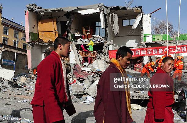 Tibetan Buddhist monks walks past the rubble of quake demolished buildings in Jiegu, Yushu County, on April 18, 2010 resulting from the devastating...