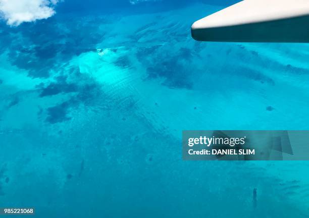 Shades of turquoise waters surround sandbanks off Eleuthera in the Bahamas as seen from a plane 25 June 2018.