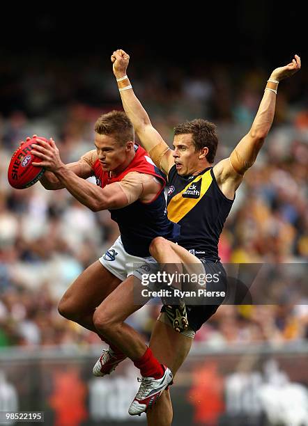 Colin Sylvia of the Demons marks in front of Brett Deledio of the Tigers during the round four AFL match between the Richmond Tigers and the...