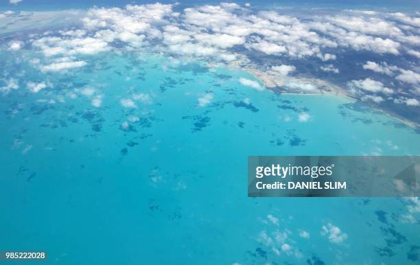Shades of turquoise waters surround sandbanks off Eleuthera in the Bahamas as seen from a plane 25 June 2018.