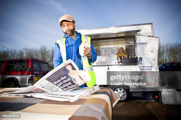 Male lorry driver takes a lunch break and reads the newspaper at Lee Swansons snack bar on the 1st February 2010 in Bishop Stortford in the United...