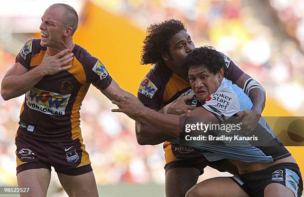 Siosaia Vave of the Sharks is tackled by Sam Thaiday of the Broncos as Darren Lockyer reacts after taking an accidental hit to the throat during the...