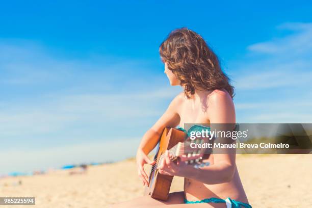 woman playing her acoustic guitar - western european culture stock pictures, royalty-free photos & images