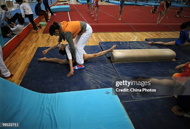 An athlete attends a training session under the instructions of a coach during the 2010 Training Camp For Country's Reserve Gymnastic Athletes at the...