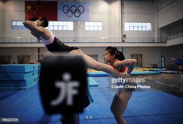 An athlete helps her teammate duing a training session of the 2010 Training Camp For Country's Reserve Gymnastic Athletes at the Gymnastic Hall of...