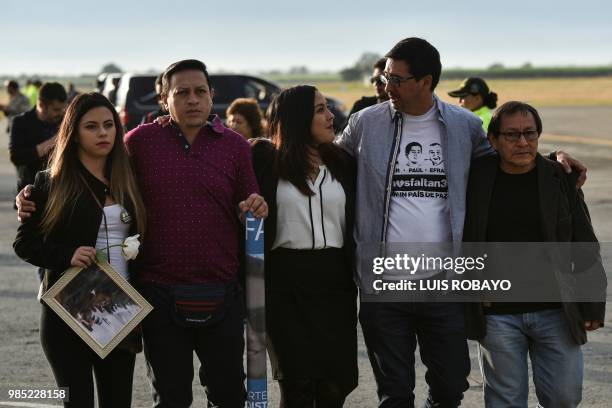 Relatives of the slain members of the news team from Ecuadorean newspaper El Comercio, walk together as the coffins containing the remains of their...